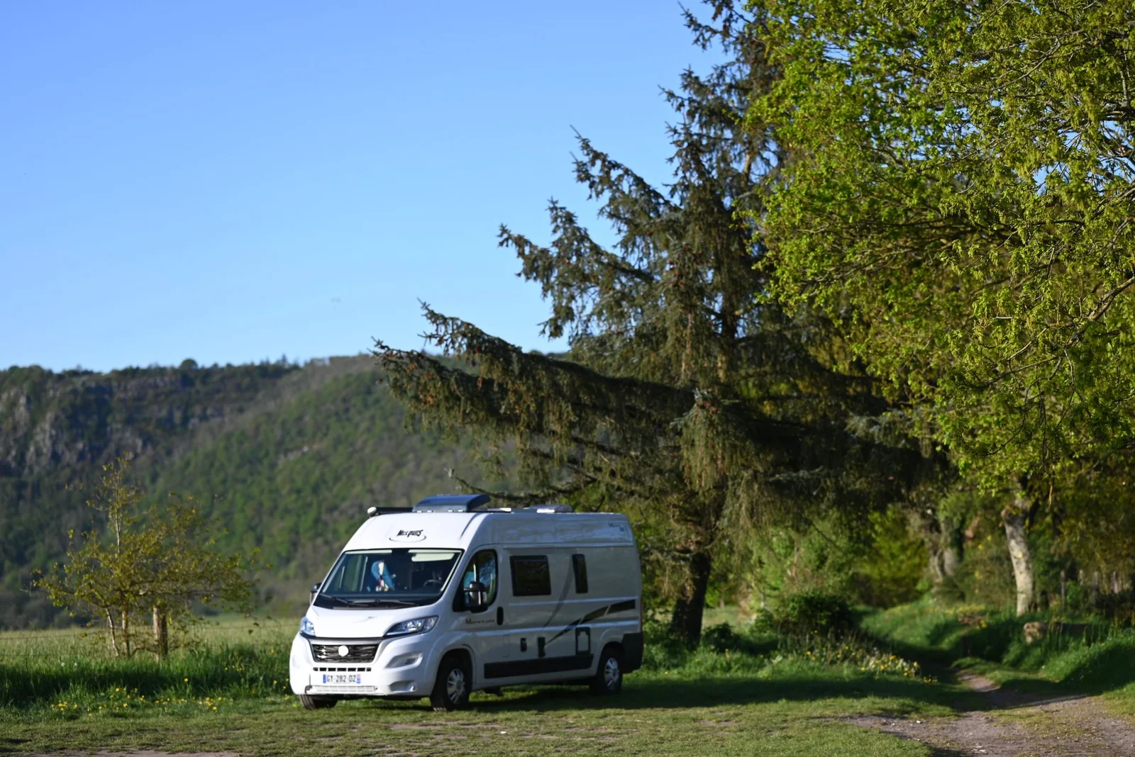 VW T6 Camper auf einem hellen Stellplatz, Entscheidung zwischen Mieten und Kaufen